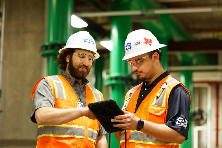 two building commissioning engineers looking at a digital tablet