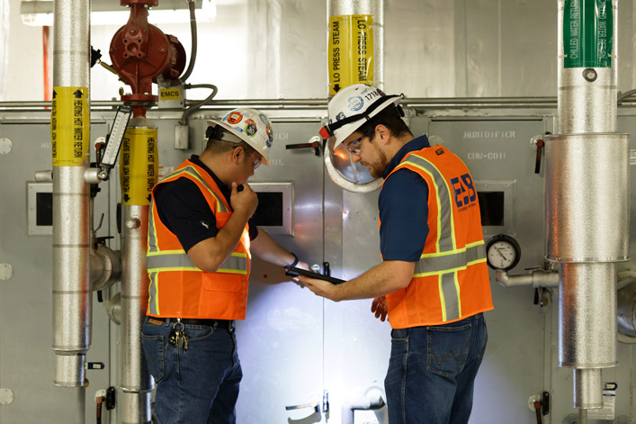 two commissioning engineers check the HVAC facility of a building